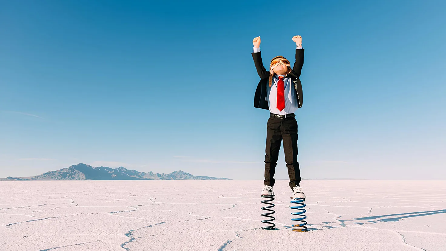 Young boy in a desert wearing a shut and springs for shoes