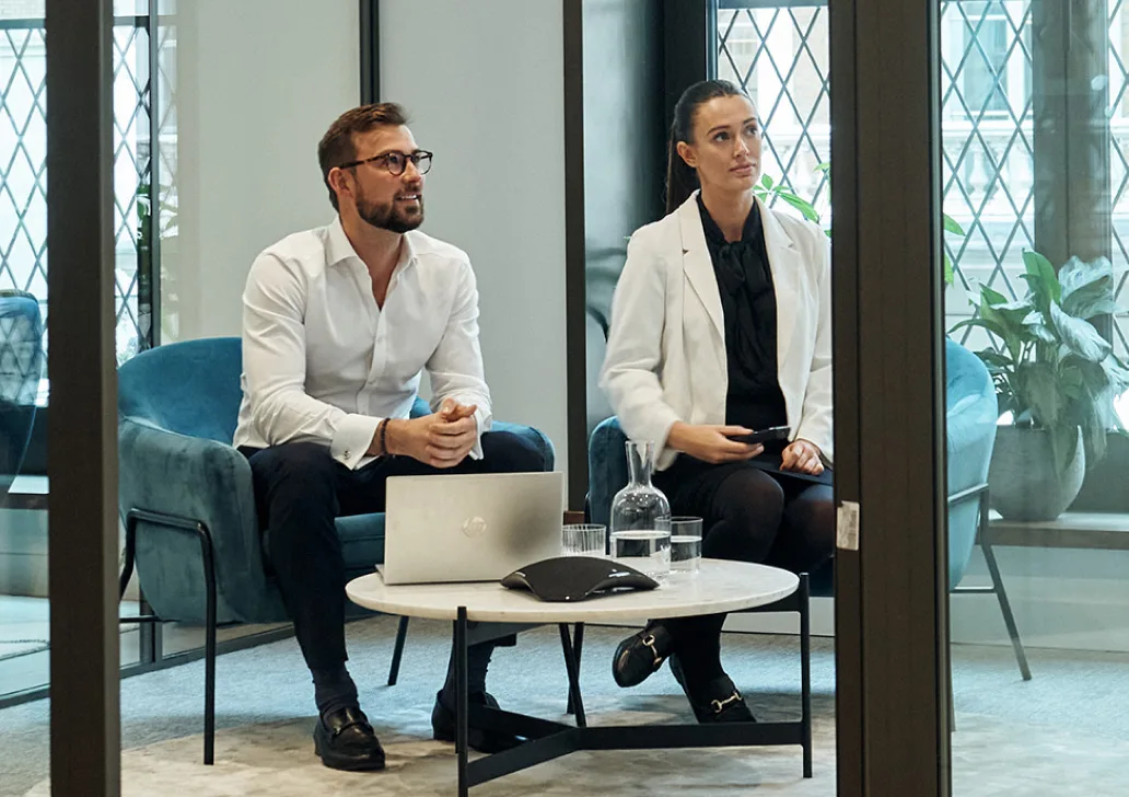 Man and a woman looking at a screen in a meeting room
