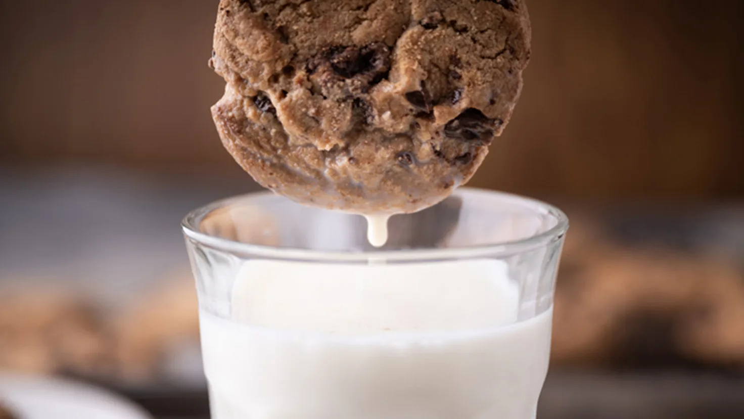 Cookie dipped into glass of milk